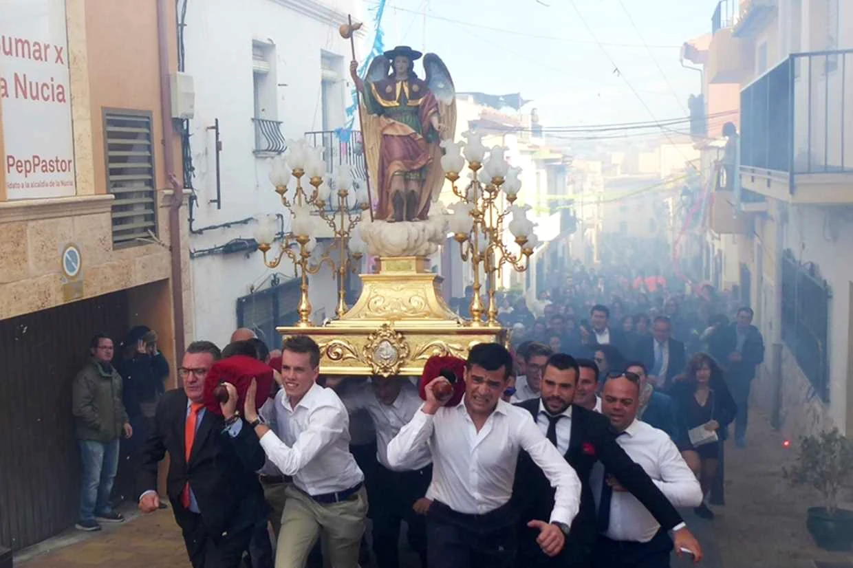 La imatge de Sant Rafel portada en processó entre la gent pels carrers de la Nucia